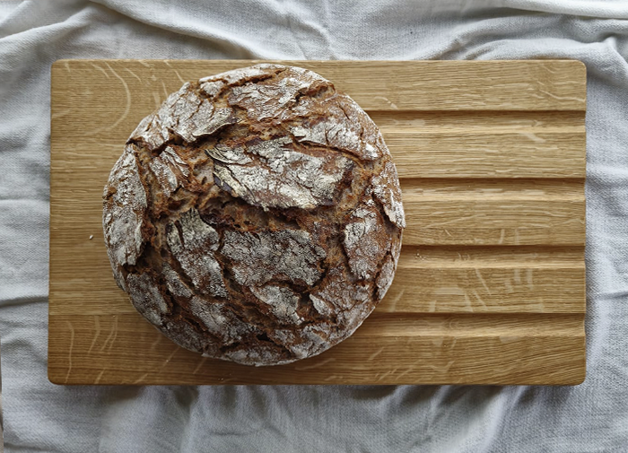 Brotschneidebrett "Falke" aus Eiche mit frischem Sauerteigbrot, ideal zum Schneiden und Servieren.