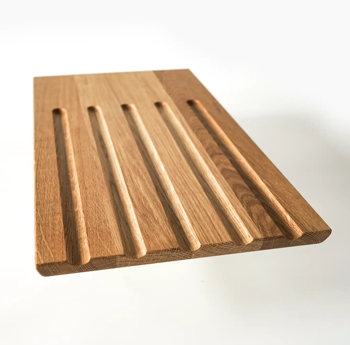 Brotschneidebrett Falke aus Eichenholz mit praktischen Krümelrillen und offenem Auswurf – ideal zum sauberen Schneiden von Brot und Brötchen.